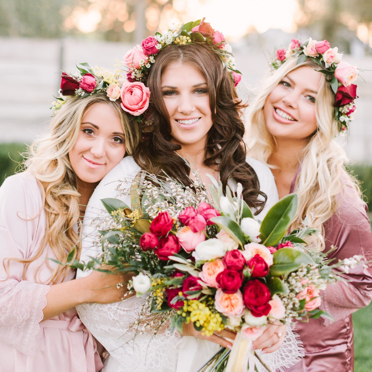 Bridesmaids and bride wearing matching robes and flower crowns