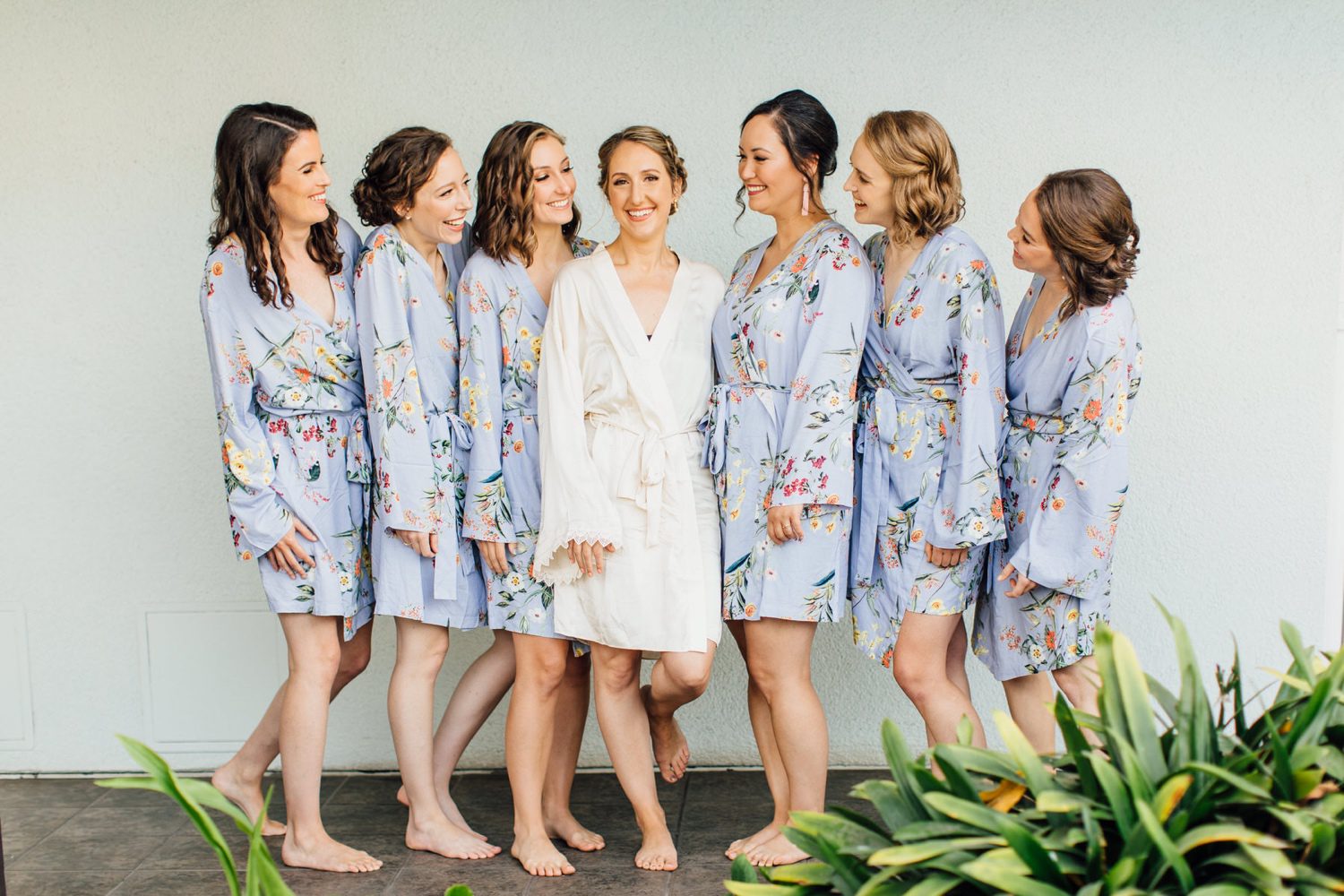 California Bride surrounded by her bridesmaids wearing matching robes.