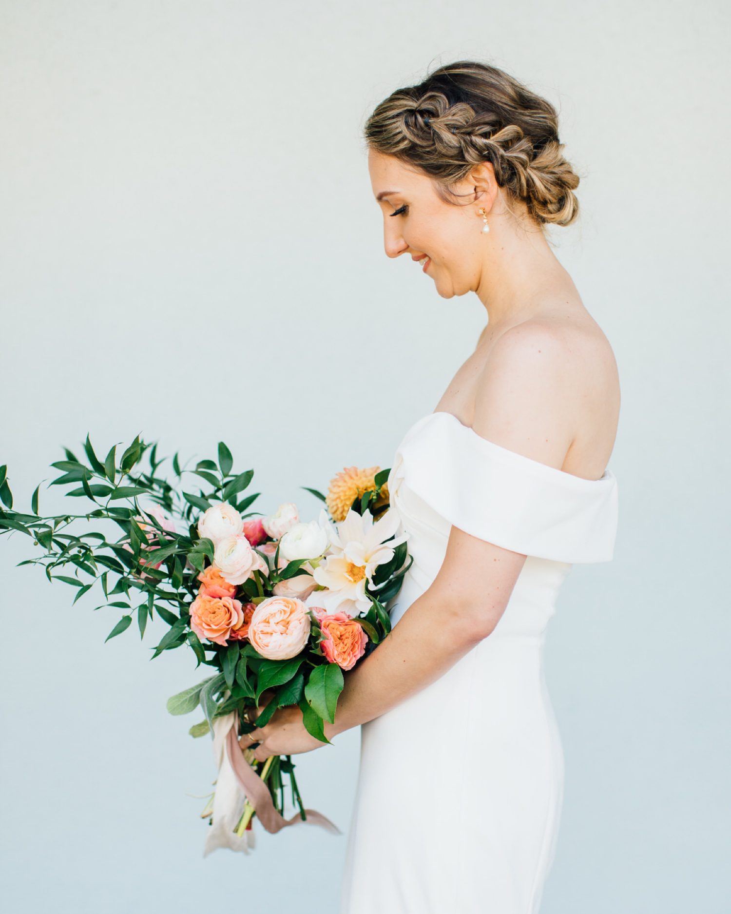 Side profile of Bride smiling down at wedding florals