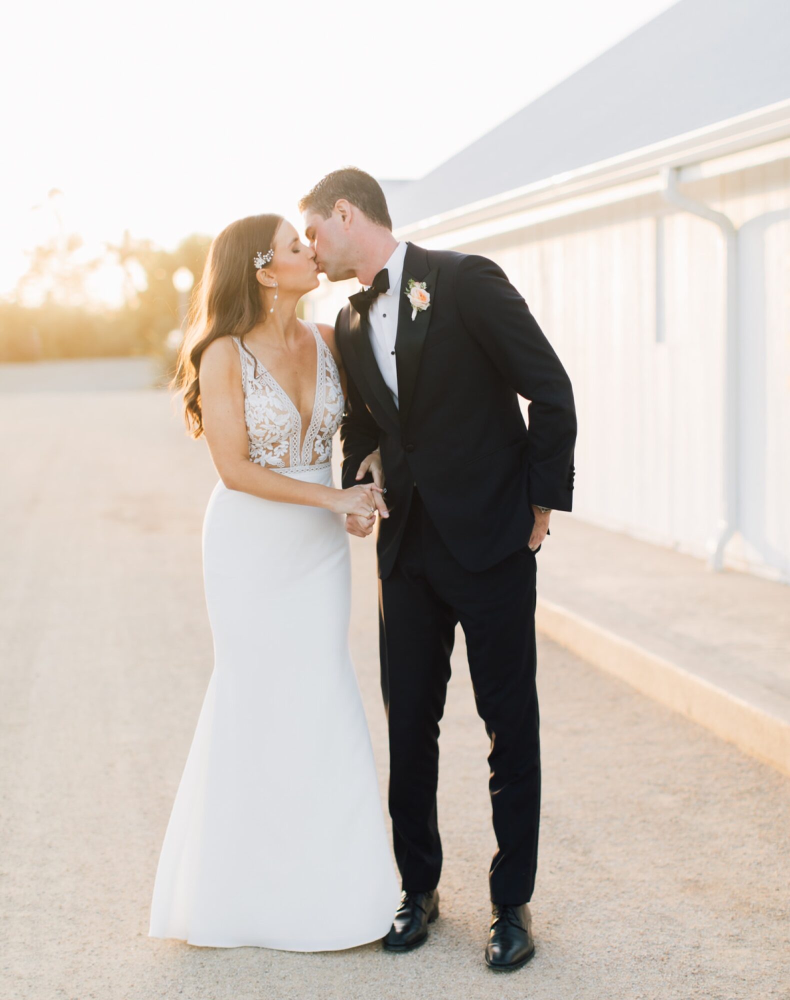 Bride and Groom kissing in the sunset glow at the White Barn Edna Valley photographed by san luis obispo wedding photographers jessica sofranko