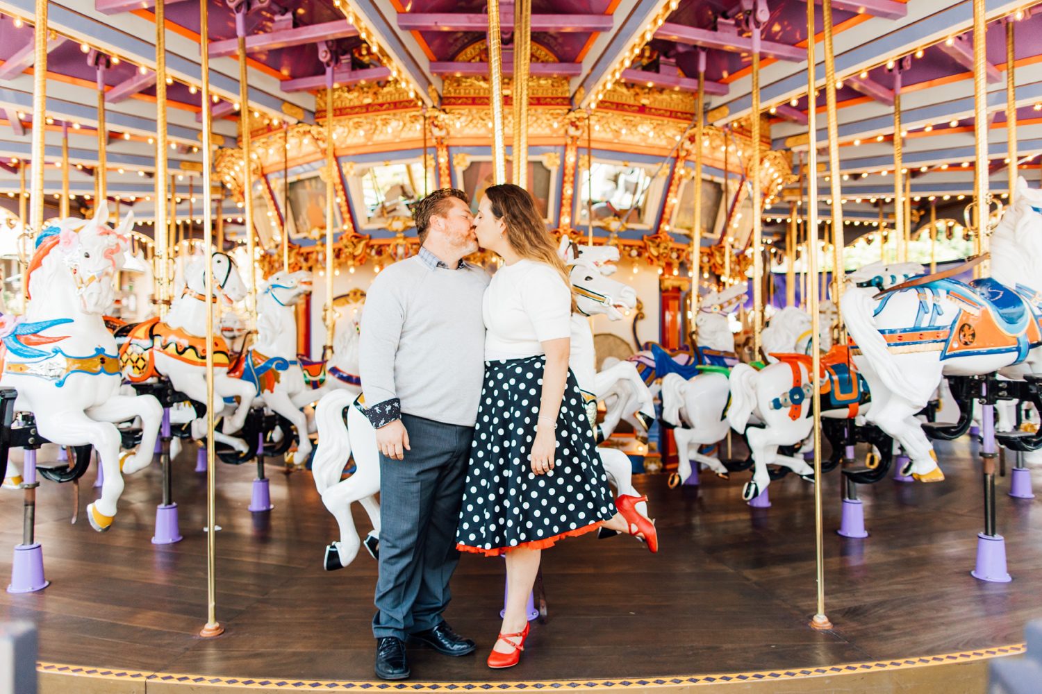 engaged couple on carousel ride at disneyland