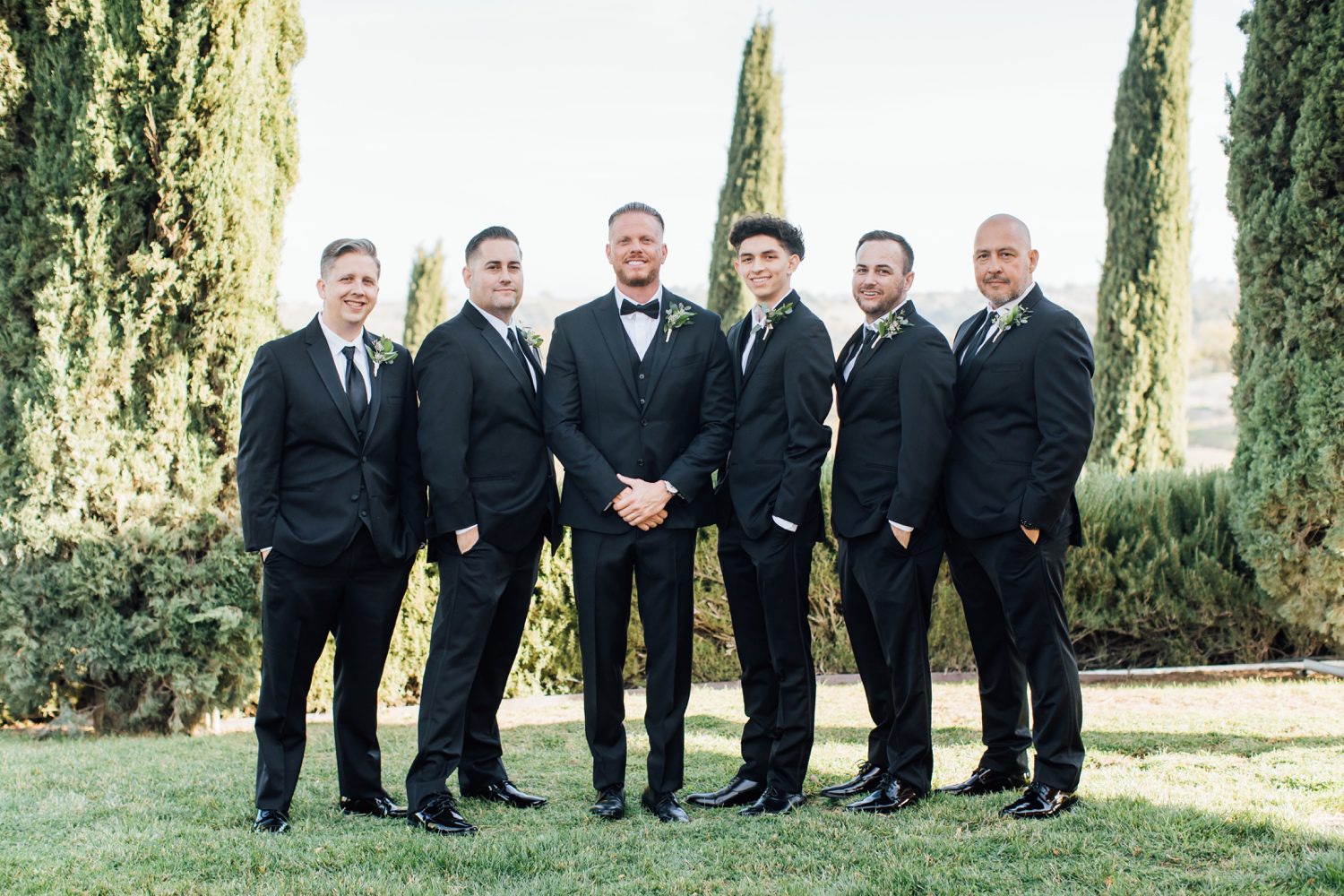 Groom standing with his groomsmen in matching suits