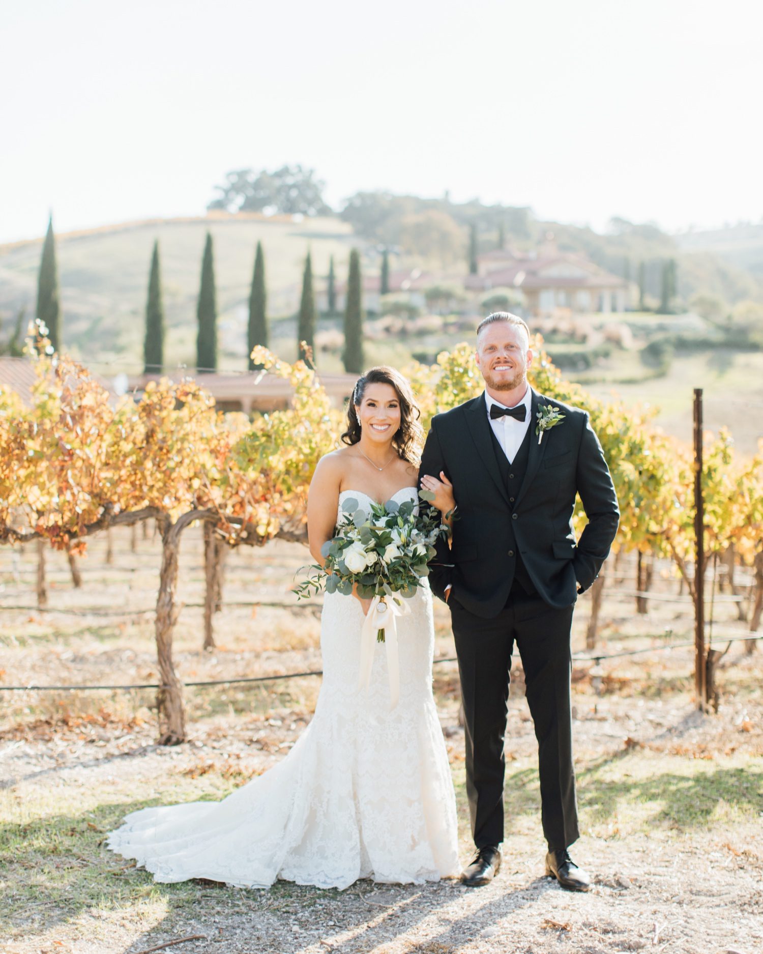 Bride and Groom in front of vineyard at Tuscany inspired wedding at Aterno Estate in Paso Robles California by wine country photographer Jessica Sofranko