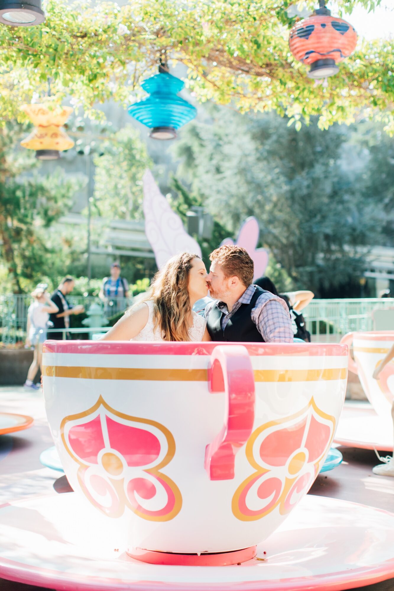 couple kissing in tea cups ride