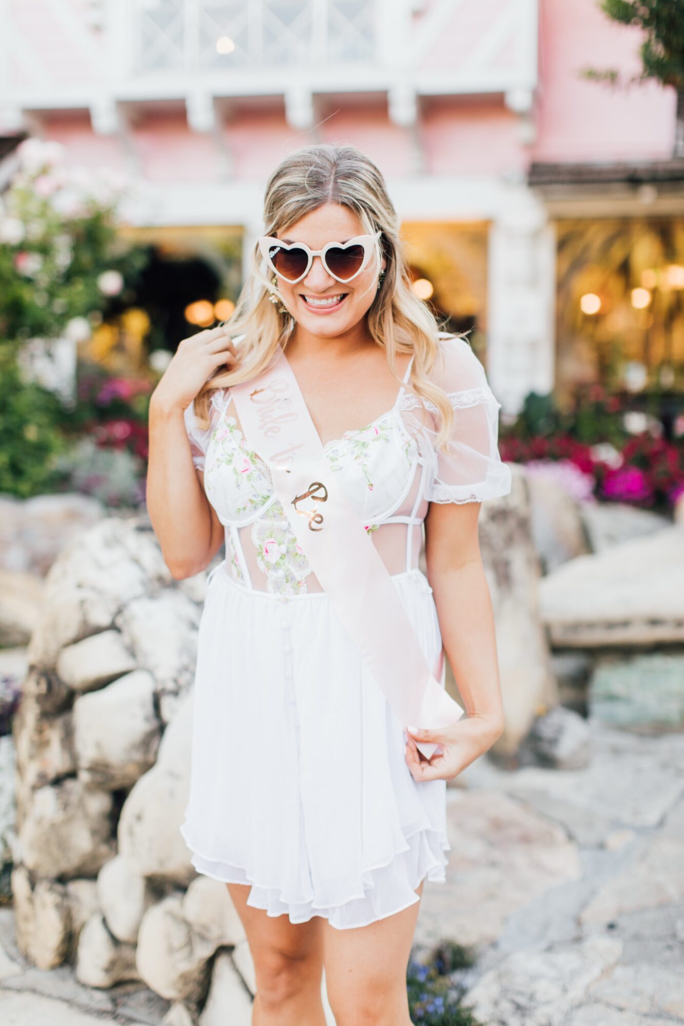 Photo of bride during bachelorette party at Madonna Inn Garden front of Copper Cafe celebrating before her wedding