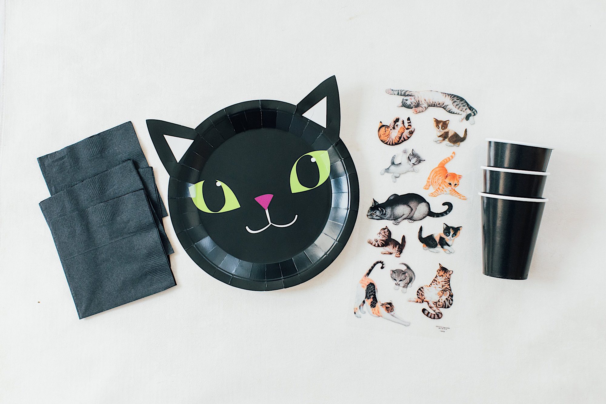 black cat plates and napkins and paper cups with cat stickers for duffy boat cat themed party
