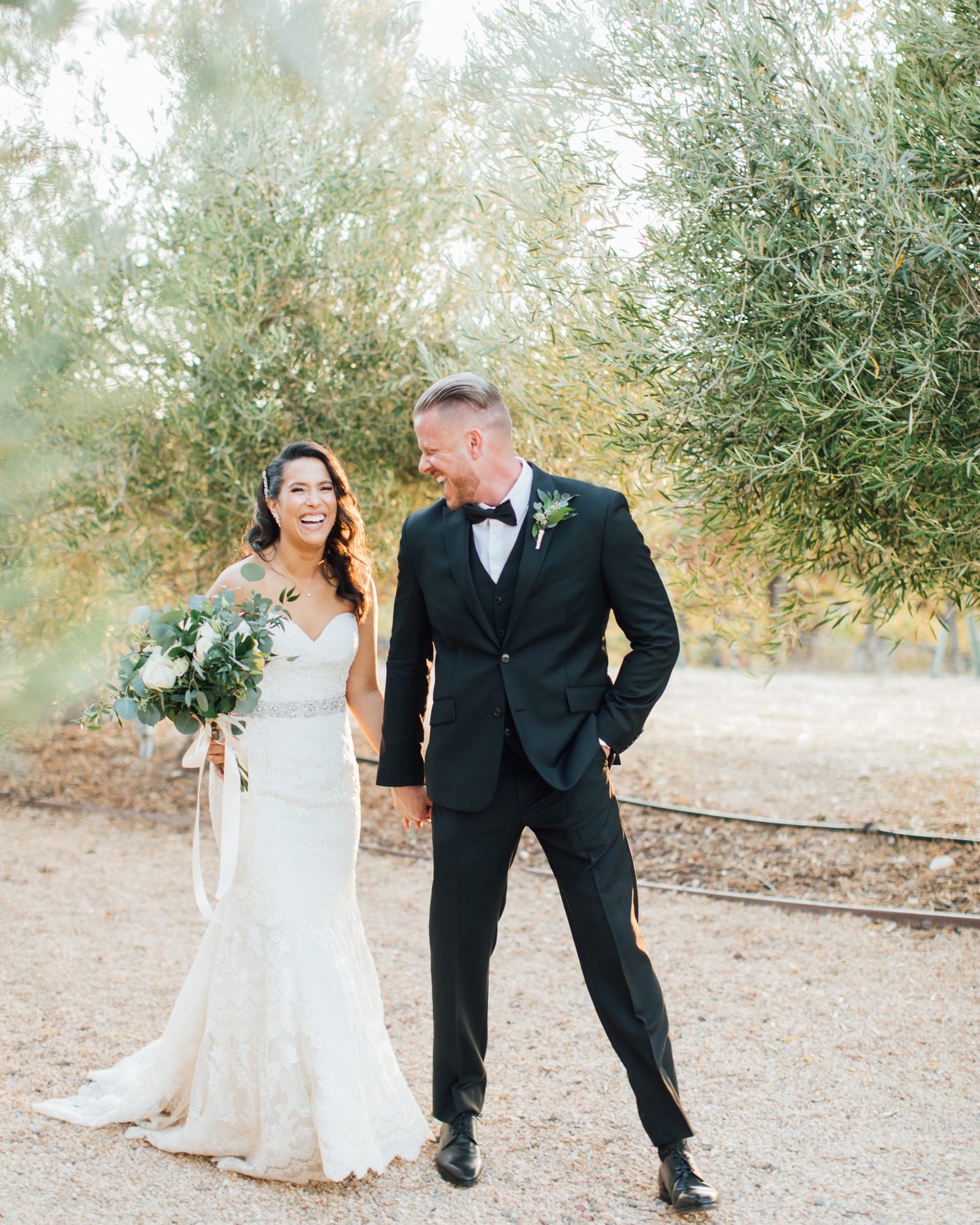 Bride and groom laughing during sunset photos in front of Olive trees at Tuscany Italy inspired wedding at Aterno Estate by photographer Jessica Sofranko