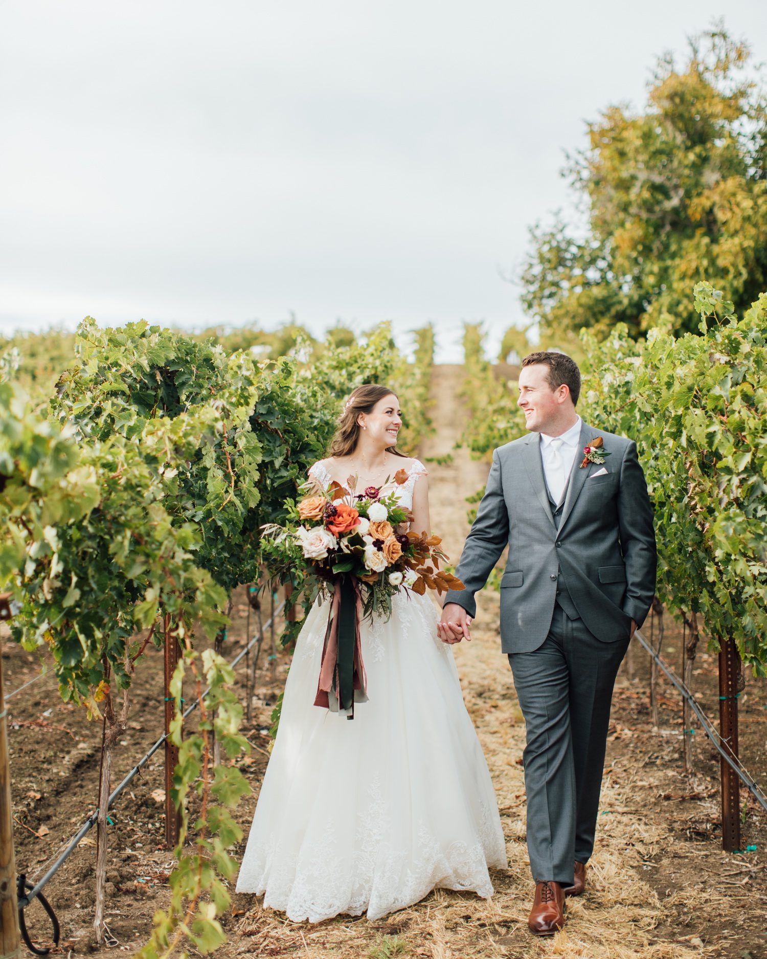 Bride and Groom walking through Paso Robles vineyard