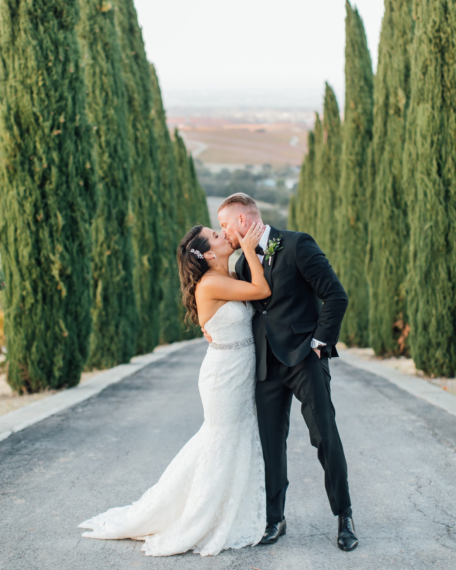 sunset photos of bride and groom in front of cyrpress trees at european chateau inspired wedding in Paso Robles by wine country photographer Jessica Sofranko