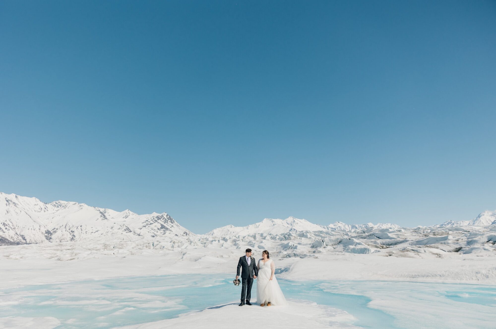Bride & Groom during elopement on Knik Glacier by destination wedding photographer Jessica Sofranko