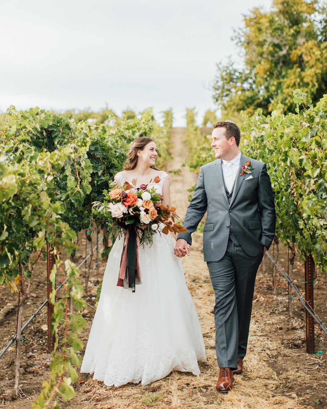 Best San Luis Obispo Winery Wedding Venues in Paso Robles Opolo Vineyard bride and groom walking in vines by photographer Jessica Sofranko